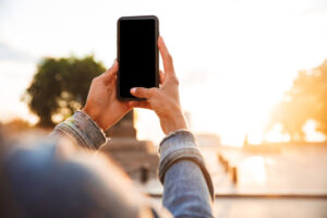 A young woman holding up her mobile phone